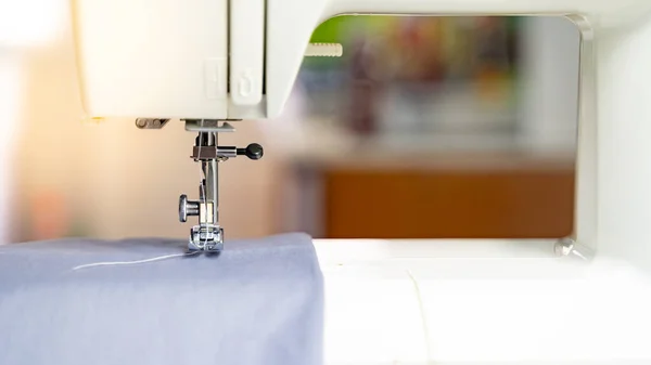 Electric sewing machine with fabric and thread