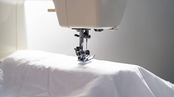 Electric sewing machine with fabric and thread