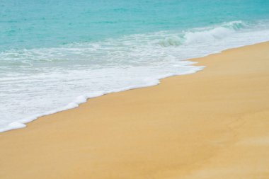 Mavi deniz dalgası arka planına sahip kumsalları kapatın.