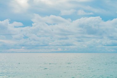 Deniz plajı ve suda yansıma, bulutlu mavi gökyüzü arkaplanı