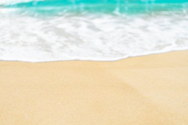 Mavi deniz dalgası arka planına sahip kumsalları kapatın.