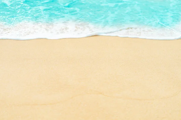 蓝色海浪背景的沙滩地闭合 免版税图库照片