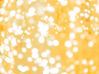 Bulanık bokeh ışığı arkaplandaki bulanıklığı gidermiş ve Noel, yeni yıl bayramı partisi ve kutlama geçmişi için dokunmuş, altın rengi