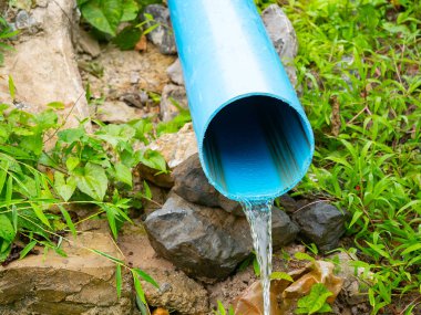 Atık su mavi boru arka planından akıyor