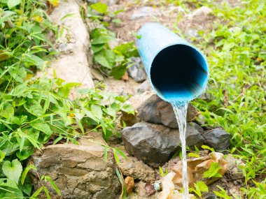 Atık su mavi boru arka planından akıyor