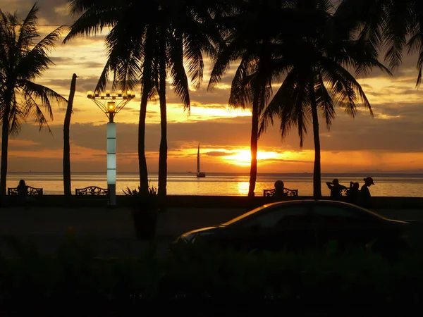 Romantischer Sonnenuntergang an einem tropischen Strand mit Palmen lizenzfreie Stockfotos