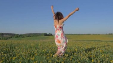 Kadın elbiseli bir çiçek sarı alanda silah yükseltir ve torna