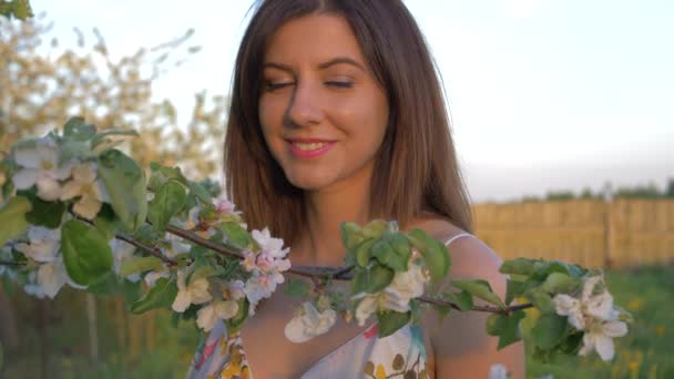 Портрет молодого кавказька жінку, що стоїть в квітучий Яблуневий сад — стокове відео
