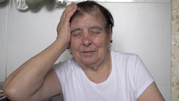 Una anciana vieja mujer caucásica está teniendo un dolor de cabeza severo — Vídeo de stock