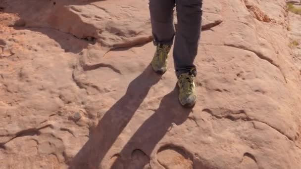 Primo piano delle gambe di un escursionista che cammina sulla roccia rossa — Video Stock