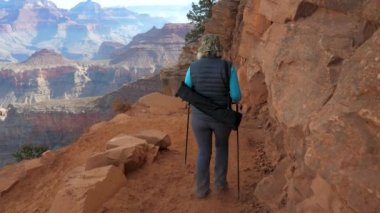 Kadın katlanmış ve döner ile serpantin izinde Grand Canyon Hiking