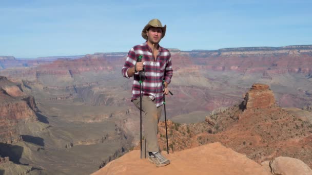 Mannen vandring vilar på bakgrunden av Grand Canyon — Stockvideo