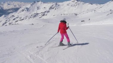 Bir dağ yamacında uzun döner aşağı hareket acemi kadın kayakçı içinde