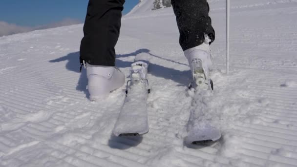 Primer plano esquiador pisando fijaciones de esquí con sus botas de esquí en un día soleado — Vídeos de Stock