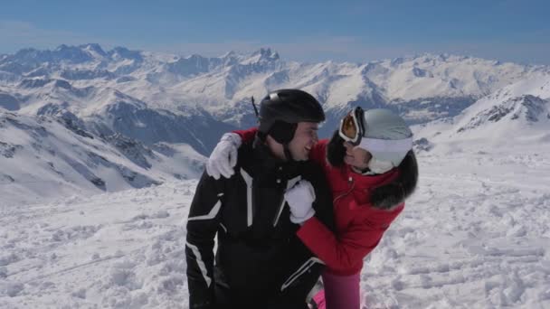 Na estância de esqui retrato de dois esquiadores abraçando beijando e caindo na neve — Vídeo de Stock
