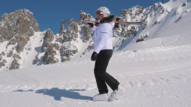 Dağ kayak merkezi içinde bir kayakçı gitmek ileri ile yokuş aşağı kayak omzunda