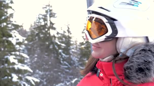 Fröhlich lächelnde kaukasische Skifahrerin erklimmt den Skilift nach oben — Stockvideo