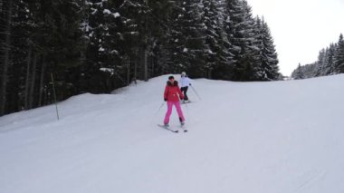 Kadın kayakçı birbiri ardına dağlarında bir kayak orman yolda binmek