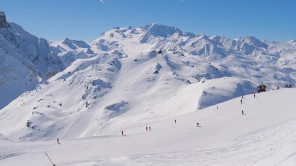阳光明媚的一天在山上滑雪胜地许多滑雪者在斜坡上 — 图库视频影像