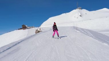 Acemi kayakçı kadın dikkatle ve dağ kayak pisti üzerinde kayak yavaşlama