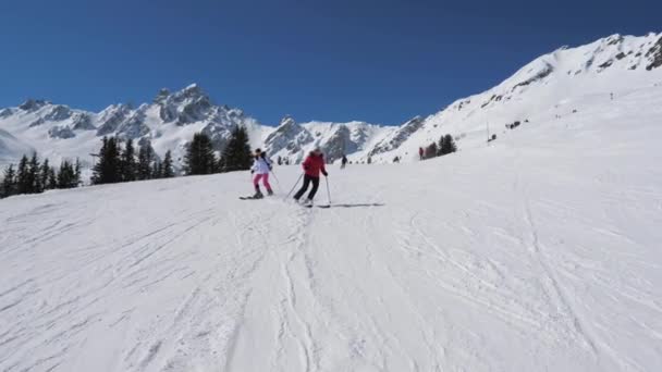 Zwei Skirennfahrerinnen im Carving-Stil am Berghang nahe beieinander — Stockvideo