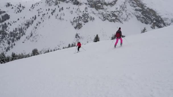 Движение возле лыжников они катаются на лыжах на сложной горы крутой склон — стоковое видео
