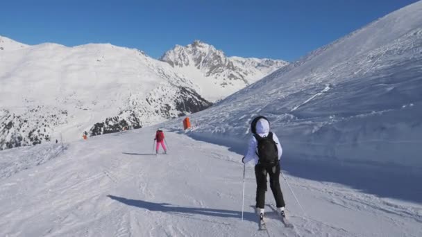 Dos esquiadoras esquiando estilo tallado en la ladera de la montaña en invierno — Vídeos de Stock