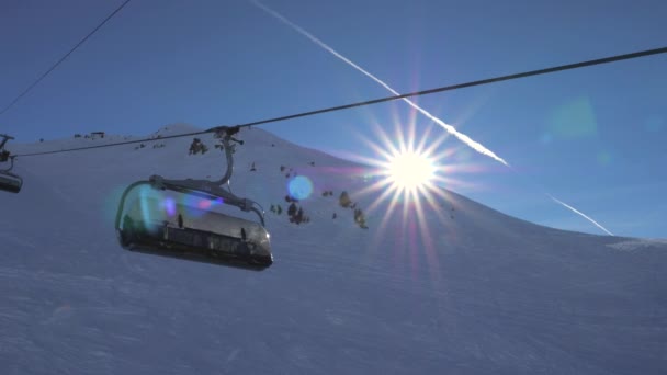 In beweging op een Ski-stoeltjeslift In de bergen, de zon schijnt en de zonsondergang — Stockvideo