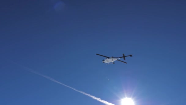 Helikopter flyger låg i bergen ovanför hans huvud vid klart soligt väder — Stockvideo