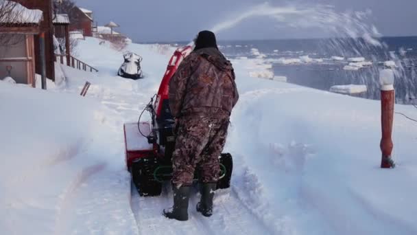 L'homme nettoie la route des machines à neige de la neige en hiver — Video