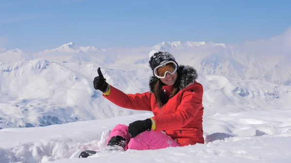 Woman Skier Shows Hand Ok And Finger Up On The Snowy Mountains Background Stock Photo