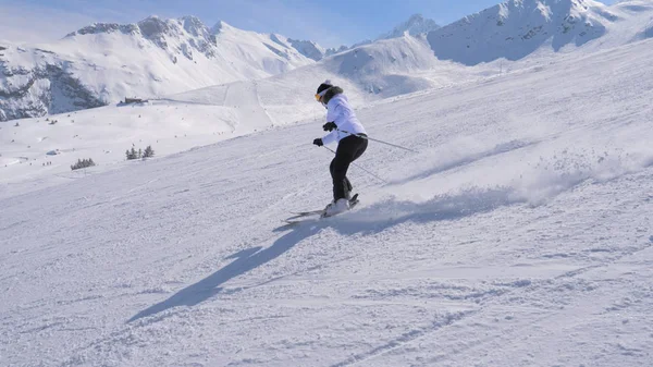 Sportliche Skirennläuferin carvt professionell den Hang in den Bergen hinunter — Stockfoto