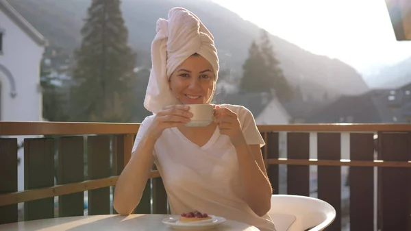 Genç kadın bir fincan çay ya da kahve güneş ışınları dağlarda içiyor