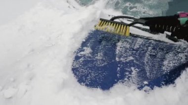 Kadınlar aktif bir fırça ile Kışın kar arabasından kaputuna temizler