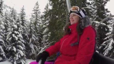 Happy Woman Skier Rises Up On The Ski Lift In The Mountains Resort In Winter
