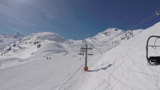 冬のスキー場の山の上に上昇するチェア リフトからのショット — ストック動画