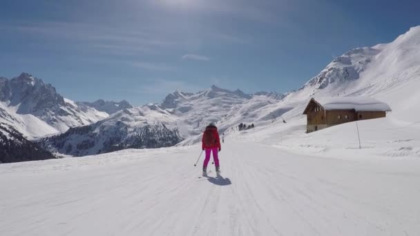 Terug kijk In Motion de skiër skiën beneden de skipiste In het Resort van bergen — Stockvideo