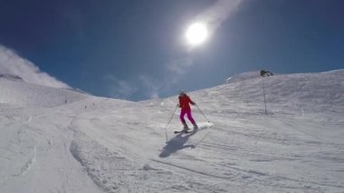 Kadın kayakçı Kayak aşağı kış dağlarda kayak yamaçta güneşli bir günde
