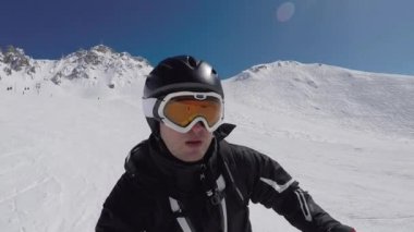 Selfie portre kez dağlarda ve fren, kandaki adrenalin bir sürü sonunda Alpin yamaç boyunca dönüm kayak kayakçı, yakın çekim. Güneş parlamayı ve ışınları, ağır çekim