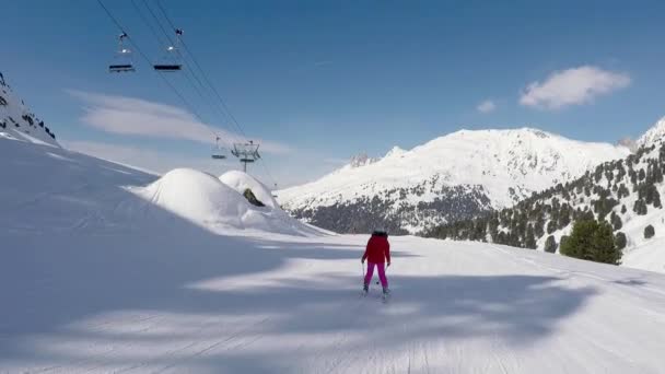 Lyžař lyžování dolů na sjezdovce v zimních horách za slunečného dne