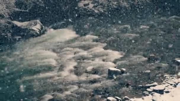 Starker Schneefall am Gebirgsfluss im Winter — Stockvideo
