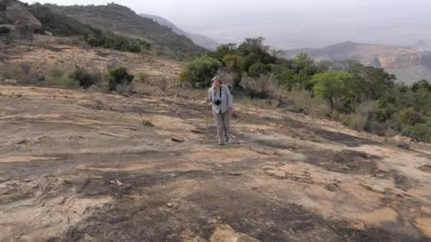 Lav soğutmalı bir taş yaylada üzerinde uyuyan bir volkan tepesine Hiking kadın — Stok video