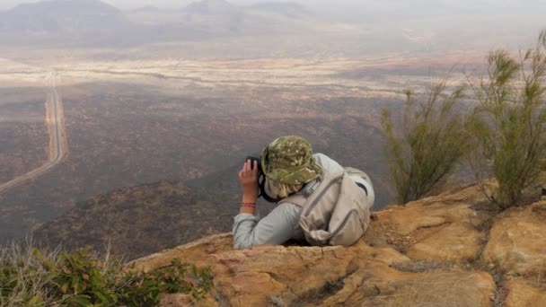 Fotograaf In de bergen ligt In een comfortabele positie om een foto te nemen — Stockvideo