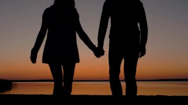 Kumsala geliyor ve denizin üzerinde güneşin tadını elele çift