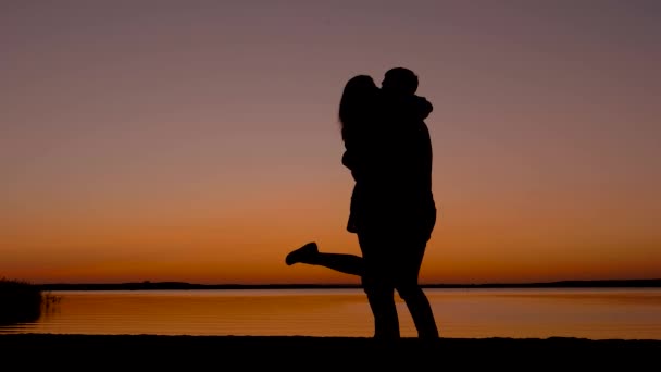 Silhouette di un amore coppia uomini e donne baci e coccole a tramonto — Video Stock