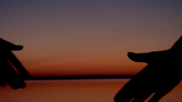 Közeli kép a kézfogás, a vörös naplemente — Stock videók