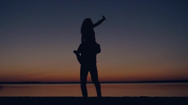 Silhouet van romantische paar kussen bij zonsondergang een Man met vrouw en spinnen — Stockvideo