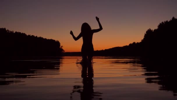 Silhouette D'une Femme Courir Genou Profondément Dans L'eau Du Lac Au Coucher Du Soleil — Video