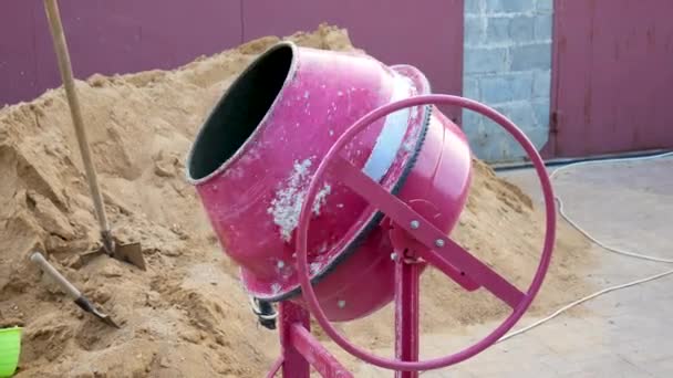 Mezclador de concreto mezcla escombros de cemento y agua en el sitio de construcción — Vídeos de Stock