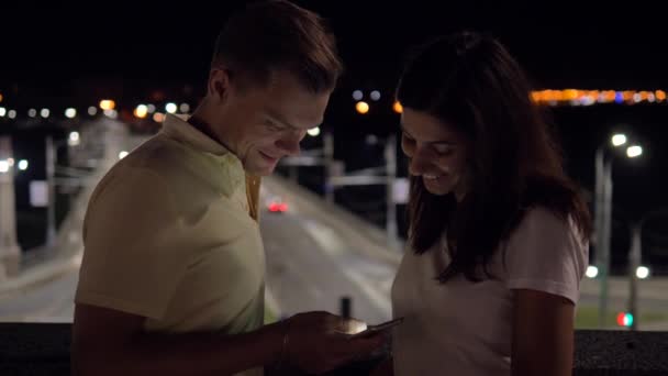 Пара ввечері на вулиці Дивлячись на смартфон Прокрутка Перегляд — стокове відео